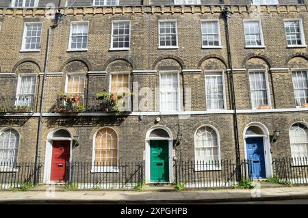 Albergo con porte frontali colorate dipinte in colori luminosi. Clerkenwell, Islington, Londra, Regno Unito. Rosso verde e blu sono i colori primari della luce Foto Stock