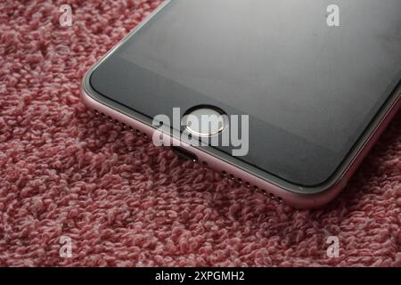Closeup of fingerprint sensor of apple iphone 7 on red background. Front panel iphone 7. Foto Stock