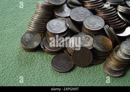 Terengganu, malesia - 23 agosto 2024: Primo piano delle monete malesi sparse su sfondo verde Foto Stock