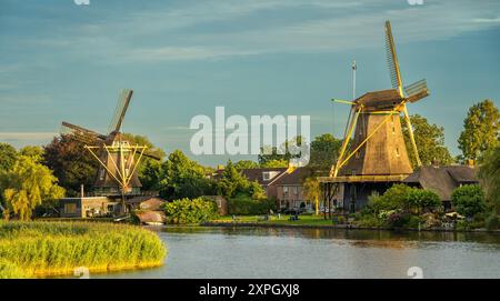 Due storici mulini a vento olandesi nella città di Weesp al tramonto Foto Stock