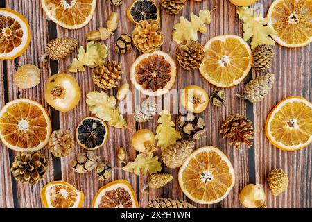 Sfondo da pezzi di arance secche, melograni, coni di pino, foglie di quercia adagiate su un tavolo di legno Foto Stock
