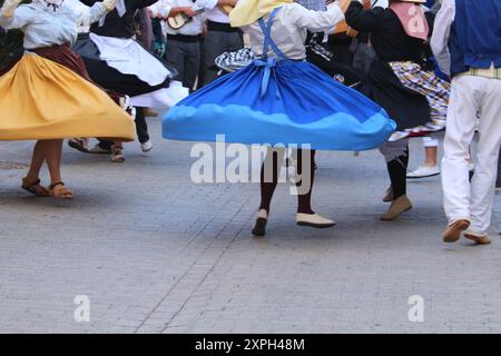 Gonne oscillanti di ballerini locali in abiti tradizionali delle Canarie in un festival pubblico, in movimento blur, la Gomera, Spagna Foto Stock
