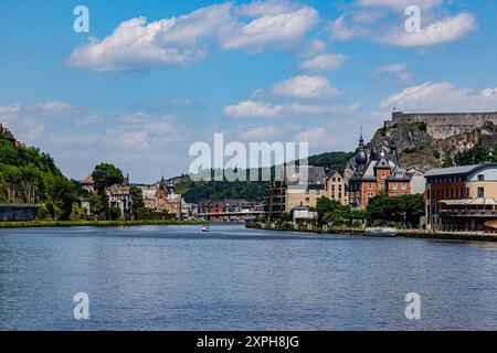 Il fiume Mosa con il paesaggio urbano di Dinant e la cittadella sulla cima di una montagna rocciosa sullo sfondo, soleggiata giornata estiva nella provincia di Namur, Vallonia, Belgio Foto Stock