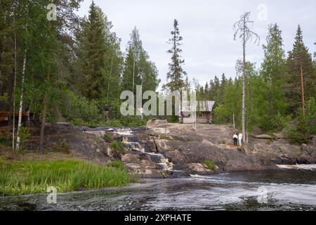 Ruskeala, Russia - 11 giugno 2021: I turisti camminano lungo la costa rocciosa presso le cascate naturali di Ruskeala. Paesaggio estivo careliano Foto Stock