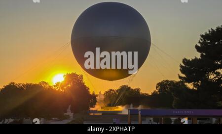 Quando il sole tramonta su Parigi, molti curiosi vengono a radunarsi intorno ai Giardini delle Tuileries per guardare il Calderone olimpico del 2024 prendere il volo Foto Stock