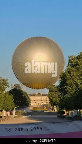 Quando il sole tramonta su Parigi, molti curiosi vengono a radunarsi intorno ai Giardini delle Tuileries per guardare il Calderone olimpico del 2024 prendere il volo Foto Stock