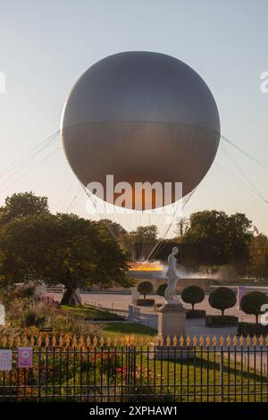 Quando il sole tramonta su Parigi, molti curiosi vengono a radunarsi intorno ai Giardini delle Tuileries per guardare il Calderone olimpico del 2024 prendere il volo Foto Stock