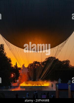 Quando il sole tramonta su Parigi, molti curiosi vengono a radunarsi intorno ai Giardini delle Tuileries per guardare il Calderone olimpico del 2024 prendere il volo Foto Stock