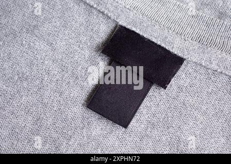 Etichetta nera vuota per indumenti da bucato sulla texture del tessuto Foto Stock