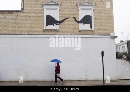 Londra, Regno Unito. 6 agosto 2024. La gente passa davanti a un nuovo murale dell'artista di strada Banksy che raffigura due elefanti in davanzali che è stato svelato a Chesea. Credito: Justin ng/Alamy Live News Foto Stock