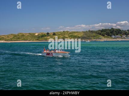 Un bellissimo motoscafo porta i passeggeri in un viaggio intorno a Rock e Padstow in Cornovaglia . La roccia può essere vista sullo sfondo. Immagini straordinarie. Foto Stock