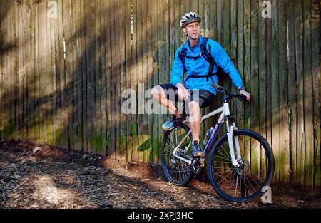 Uomo, bicicletta e pausa dall'avventura ciclistica all'aria aperta, pensare e pianificare per gli sport estremi. Persona maschile, atleta rilassarsi e allenarsi in natura per Foto Stock