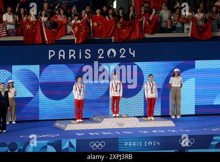 Parigi, Francia. 6 agosto 2024. Olimpiadi di Parigi: IMMERSIONI - finali di 10 metri femminili - (da sinistra a destra) medaglia d'argento Yuxi Chen, medaglia d'oro Hongchan Quan della Cina e medaglia di bronzo Kim mi Rae della Corea durante la cerimonia della medaglia sotto un mare di bandiere cinesi, durante il giorno 11 dei Giochi Olimpici di Parigi 2024 presso il Centro acquatico di Parigi, Francia. Crediti: Adam Stoltman/Alamy Live News Foto Stock