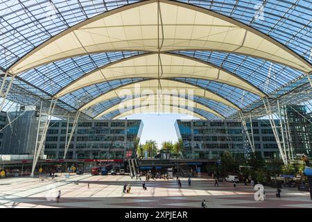MONACO, GERMANIA - 6 AGOSTO 2024: Vista esterna dell'aeroporto di Monaco in una giornata di sole che collega il suqare tra i Terminal 1 e 2 con una grande rivendicazione Lufthansa Foto Stock