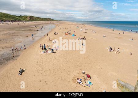 Persone che amano il sole estivo sulla spiaggia di Saltburn-by-the-Sea, Yorkshire, Inghilterra, Regno Unito Foto Stock