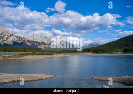 Un'incredibile vista di un lago naturale di montagna in una soleggiata giornata estiva sullo sfondo delle montagne rocciose dell'Alberta in Canada Foto Stock