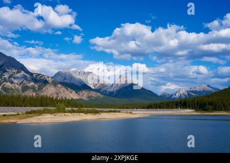 Un'incredibile vista di un lago naturale di montagna in una soleggiata giornata estiva sullo sfondo delle montagne rocciose dell'Alberta in Canada Foto Stock