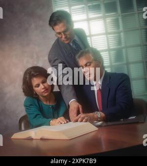 Professionisti aziendali che esaminano documenti legali al tavolo delle conferenze, avvocati che consigliano i clienti, riunioni aziendali con discussione sui contratti in ambienti chiusi Foto Stock