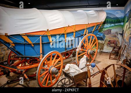 Virginia Freight Wagon Luray Virginia // LURAY, Virginia, Stati Uniti — un Virginia Freight Waggon del 1810, costruito a Newtown (ora Stephens City), Virginia, è in mostra al Luray Valley Museum. Questo tipo di carro, tipicamente trainato da una squadra di sei cavalli con campane, era cruciale per il trasporto di merci dalla valle dello Shenandoah a Baltimora, giocando un ruolo vitale nel commercio americano all'inizio del XIX secolo prima dell'avvento dei canali e delle ferrovie. Foto Stock