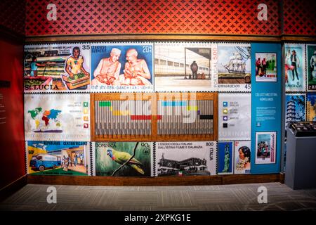 Francobolli da tutto il mondo allo Smithsonian National Postal Museum di Washington DC | WASHINGTON D.C., Stati Uniti - riproduzioni di francobolli ingranditi coprono una parete della galleria allo Smithsonian National Postal Museum, parte della mostra "francobolli da tutto il mondo" che raggruppa i francobolli per continente utilizzando una chiave codificata a colori. I disegni in vista spaziano dall'industria delle banane di Santa Lucia a un commemorativo Gandhi e Nehru emesso dall'India. Foto Stock