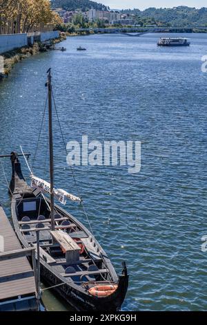 Molo per gite turistiche in barca e il ponte di Santa Clara sul fiume Mondego nella città di Coimbra, Portogallo Foto Stock