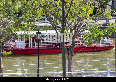 I visitatori si siedono all'interno di una crociera in barca lungo il fiume Singapore ammirando il paesaggio circostante. Singapore. SG, Sud-est asiatico. Foto Stock