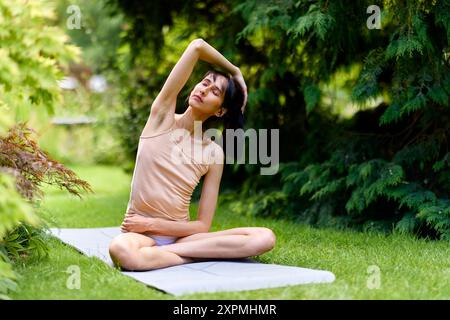 Donna che pratica yoga all'aperto Foto Stock