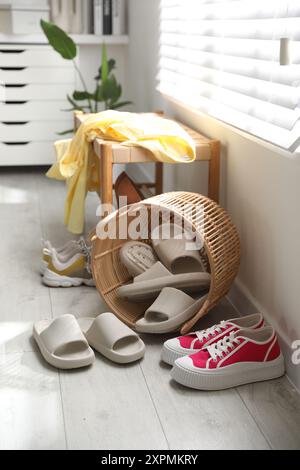 Cestino con pantofole per gli ospiti e scarpe da ginnastica all'ingresso di casa Foto Stock