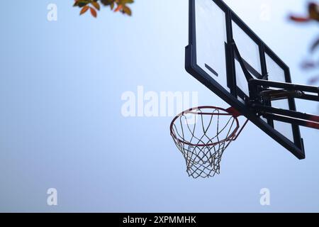 Silhouette di un canestro da basket contro un cielo blu Foto Stock