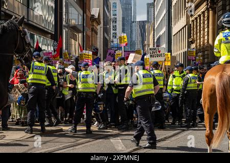 Gli agenti di polizia gestiscono grandi folle a Manchester durante una settimana di disordini nazionali. Foto Stock