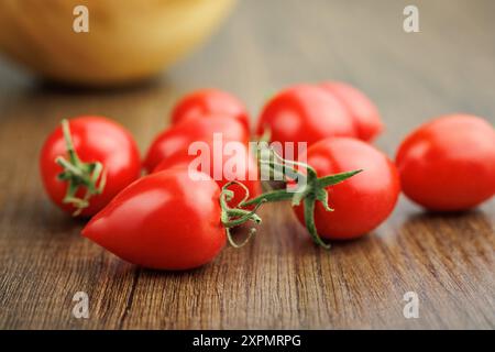 Pomodori ciliegini rossi su un tavolo di legno. Foto Stock