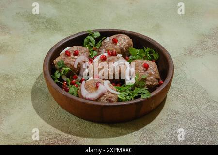 Polpettine di manzo fritte georgiane - Apkhazura in pentola di argilla decorata con semi di melograno, fette di cipolla rossa e coriandolo Foto Stock