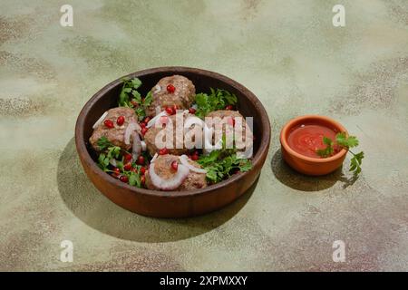 Polpettine di manzo o agnello fritte avvolte in grasso intestino - Apkhazura in pentola di argilla e piccolo recipiente con salsa ajika Foto Stock