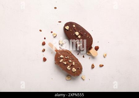 Delizioso gelato al cioccolato con noci tritate su tavolo bianco Foto Stock