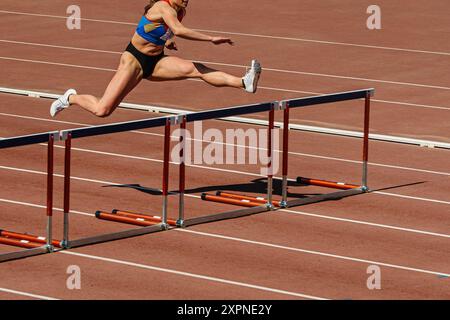 la gara di ostacoli di 100 metri è un'atleta leader nel settore Foto Stock