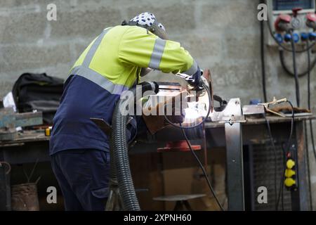 Uomo di metallo di saldatura in una fabbrica Foto Stock