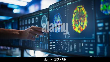 Modern Medical Research Center: Medico anonimo che punta al monitor di computer desktop con scansione TC del midollo spinale del paziente. Specialista in cerca di tumori o danni, in cerca di metodi di trattamento. Foto Stock