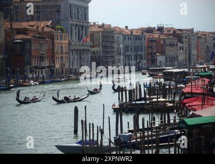 I gondolieri trasportano i turisti in giro in gondole sui canali di Venezia in Italia. Venezia è una città dell'Italia nord-orientale e la capitale della Veneta Foto Stock