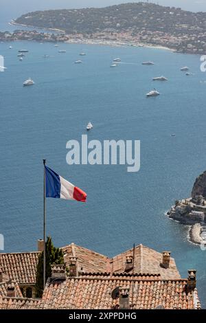 Bandiera francese che sventola nel vento con il mare blu e yacht sullo sfondo a Nizza, Francia Foto Stock