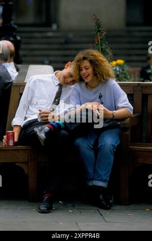 Amanti dell'ora di pranzo, due giovani uffici lavorano a flirtare tra loro durante l'ora di pranzo. Sta bevendo lattina di Coca-Cola, con la testa sulla spalla che sta fumando una sigaretta. City of London, Inghilterra giugno 1992 1990s Regno Unito HOMER SYKES Foto Stock