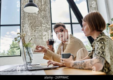 Due amici si godono un caffè e una conversazione coinvolgente in un ambiente accogliente. Foto Stock