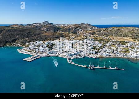 Vista aerea di un gommone dalla nave da crociera a vela che corre sulle onde (M&#39;Oceano) lasciando il porto con la città alle spalle, Adamas, Milos, Egeo meridionale, GRE Foto Stock