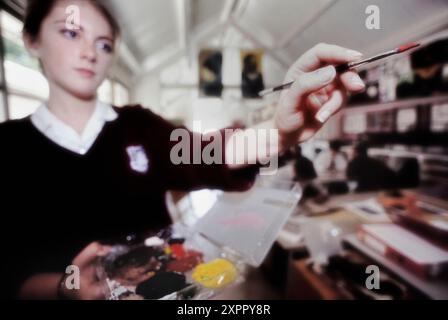 Studentessa che dipinge nell'aula d'arte a scuola. Inghilterra. REGNO UNITO Foto Stock
