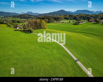 Diverse persone pedalano attraverso le colline alpine, Siegsdorf, la pista ciclabile del lago di Costanza-Königssee, l'alta Baviera, la Baviera, la Germania Foto Stock