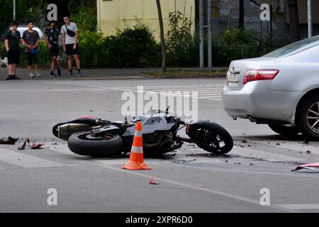 Kiev, Ucraina. 6 agosto 2024. Un casco da motociclista visto a terra mentre un'ambulanza vista sullo sfondo vicino alla scena dell'incidente. Un incidente stradale si verificò all'incrocio tra via Saliutna e viale Pavlo Virsky. Un motociclista è stato portato via da un'ambulanza in cattive condizioni. Credito: SOPA Images Limited/Alamy Live News Foto Stock