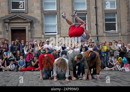 Edinburgh Festival Fringe, Royal Mile, Scozia, Regno Unito. 7 agosto 2024. Mercoledì ventoso sulla High Street per gli artisti di strada punteggiati da docce blustery, raffiche di vento a 35 km/h di temperatura di 19 gradi nel pomeriggio. Nella foto: Karbula salta sul pubblico volontario. Notizie dal vivo Credit/Arch White/alamy. Foto Stock