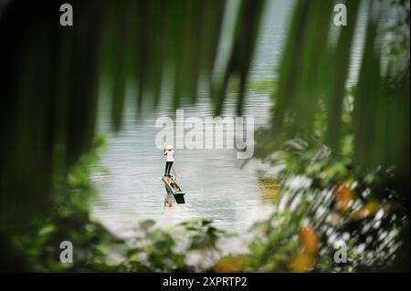 Donna che pesca in una piroga sul lago di Ba Be, nella provincia di Bac Kan, nel nord del Vietnam, nel sud-est asiatico Foto Stock
