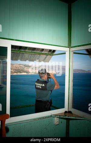 Un ufficiale della Guardia Civil viene visto usare un binocolo per sorvegliare il confine esterno dell'Unione europea da una torre di guardia a Melilla, un'enclave spagnola in Africa, nel giugno 2012. Foto Stock