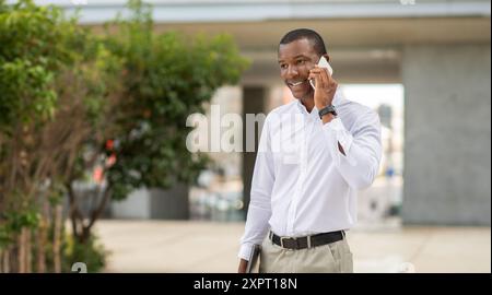 Camicia bianca professionale sorridente per telefonare all'aperto Foto Stock
