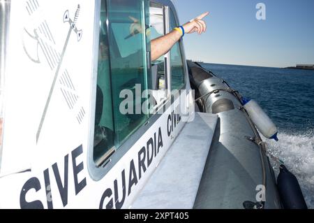 Guardia Civil ufficiali che sorvegliano le frontiere esterne dell'Unione europea con l'Africa a Melilla, Spagna. L'immagine cattura la loro attività su un motoscafo nelle acque del giugno 2012. Foto Stock